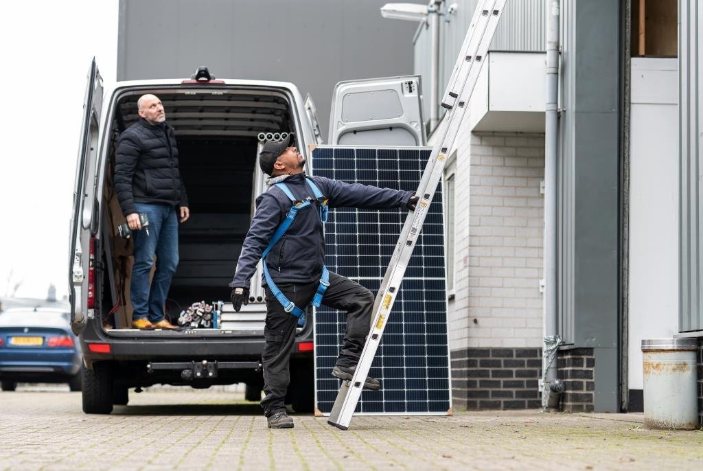 Statushouder Msgina Albraha staat op een ladder. Hij is met een collega aan het werk bij Sungarant. Via het STT is hij uitgestroomd naar deze reguliere baan. 