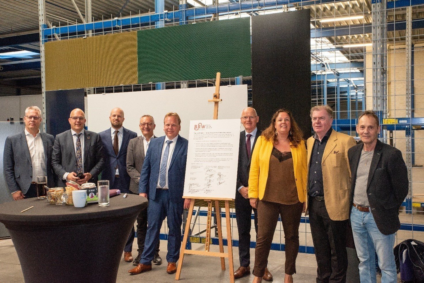 een groep mensen die naast een tafel staat