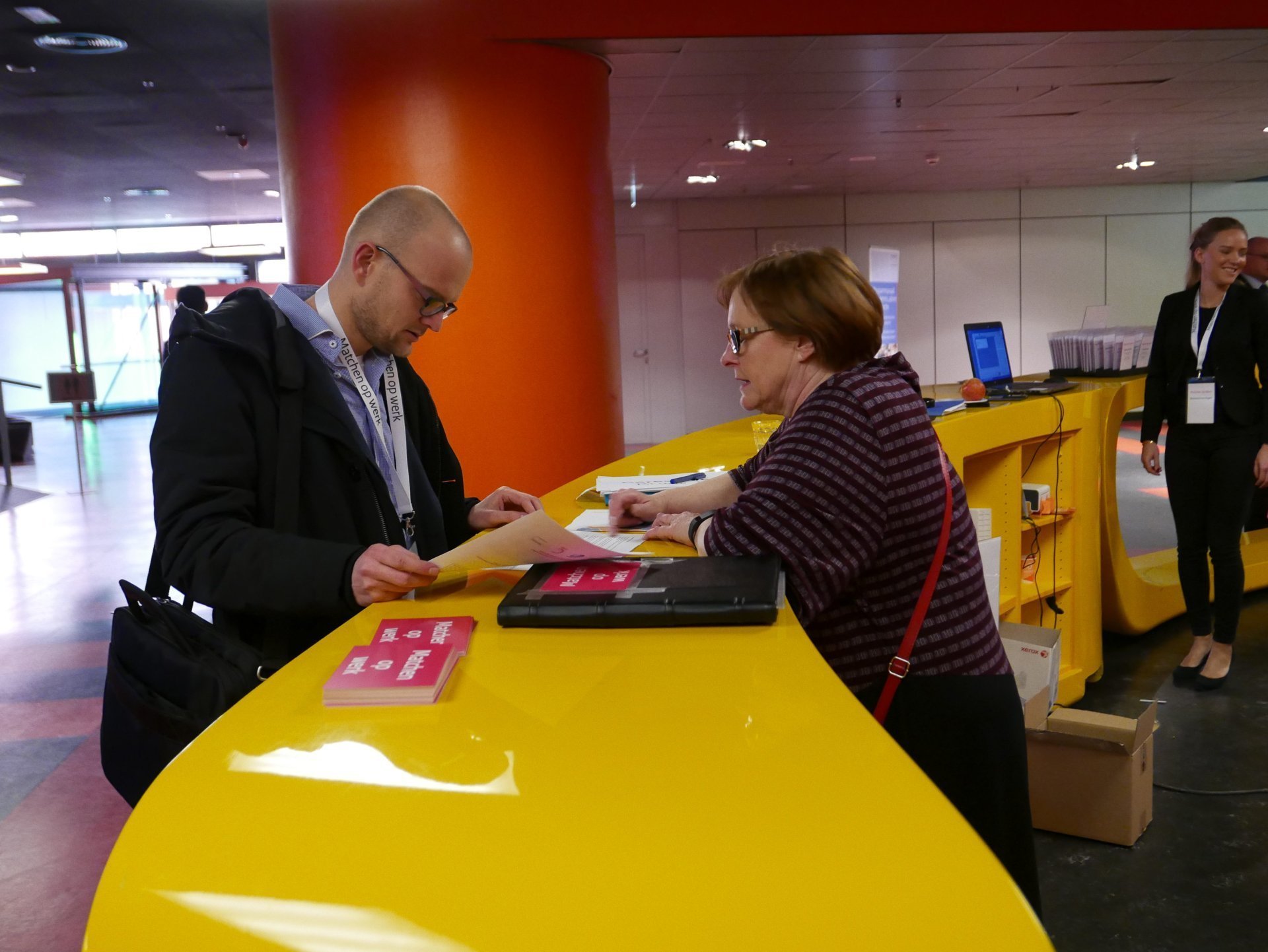 een man en een vrouw die naar een scherm van een laptop kijken