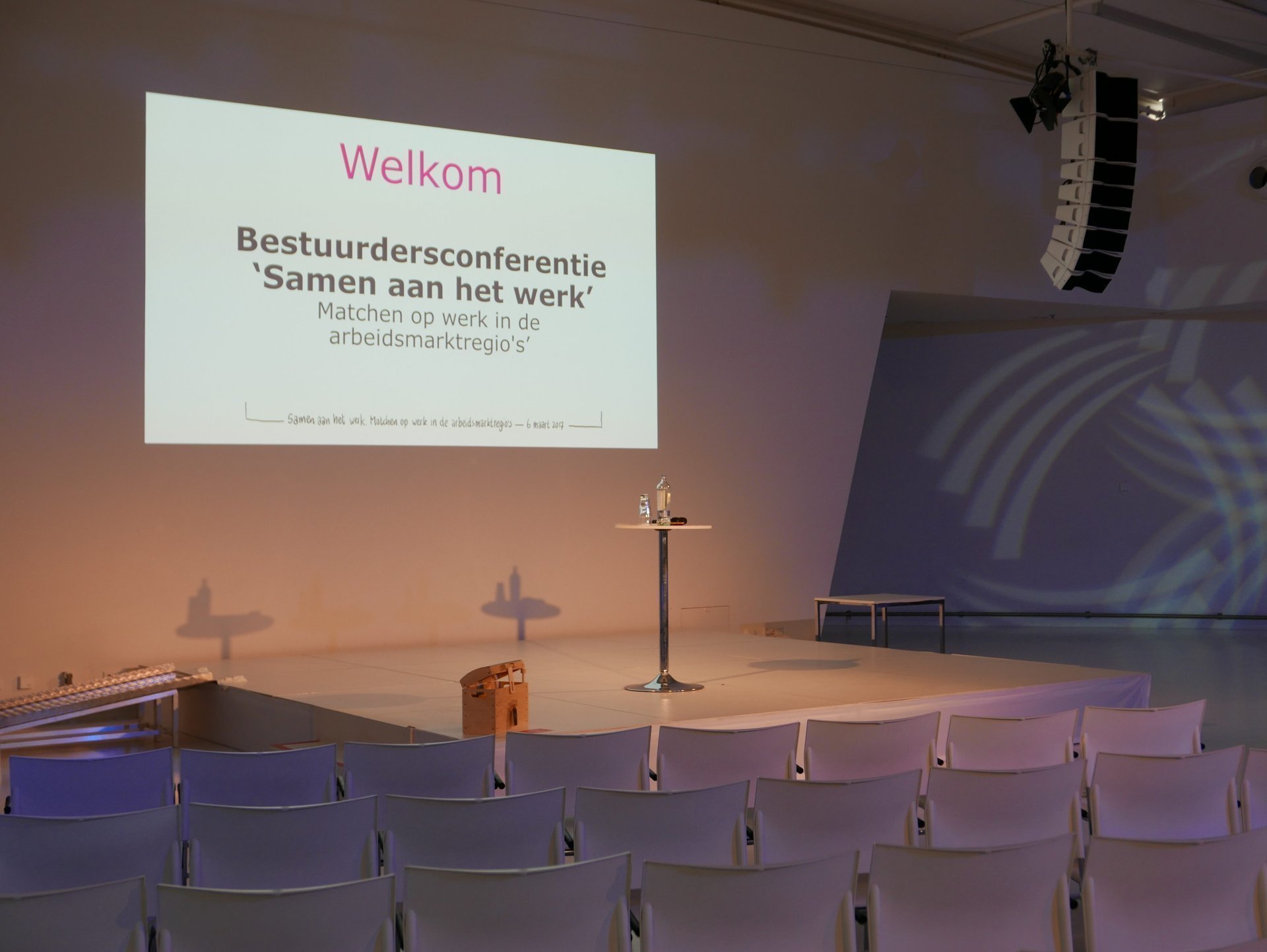 een podium met een scherm en stoelen
