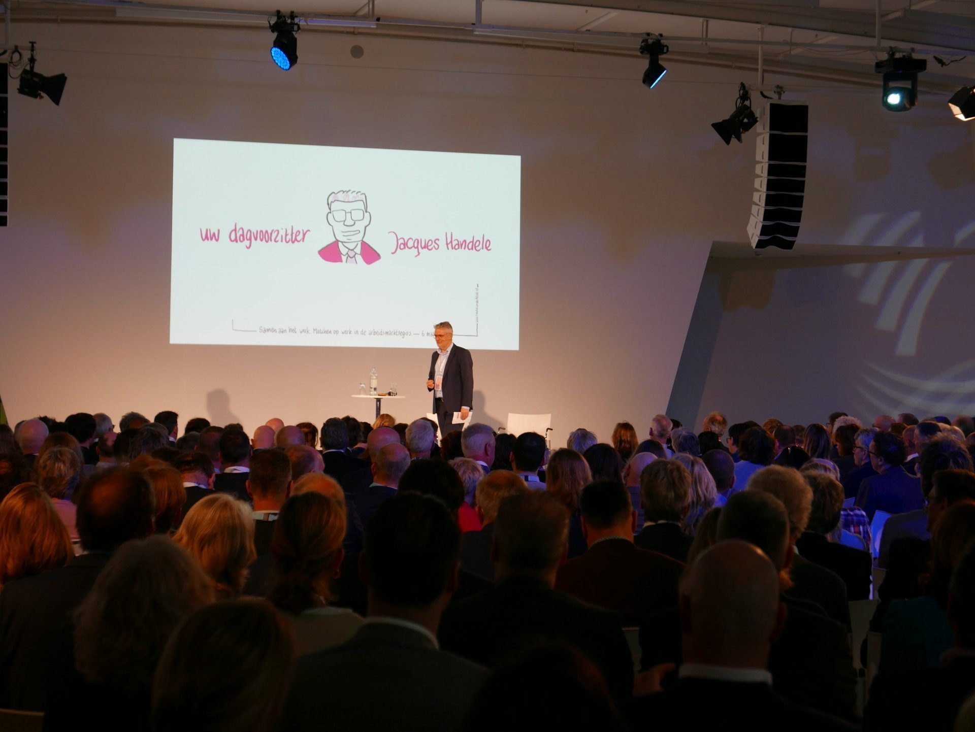 een persoon die op een podium staat met een menigte die toekijkt