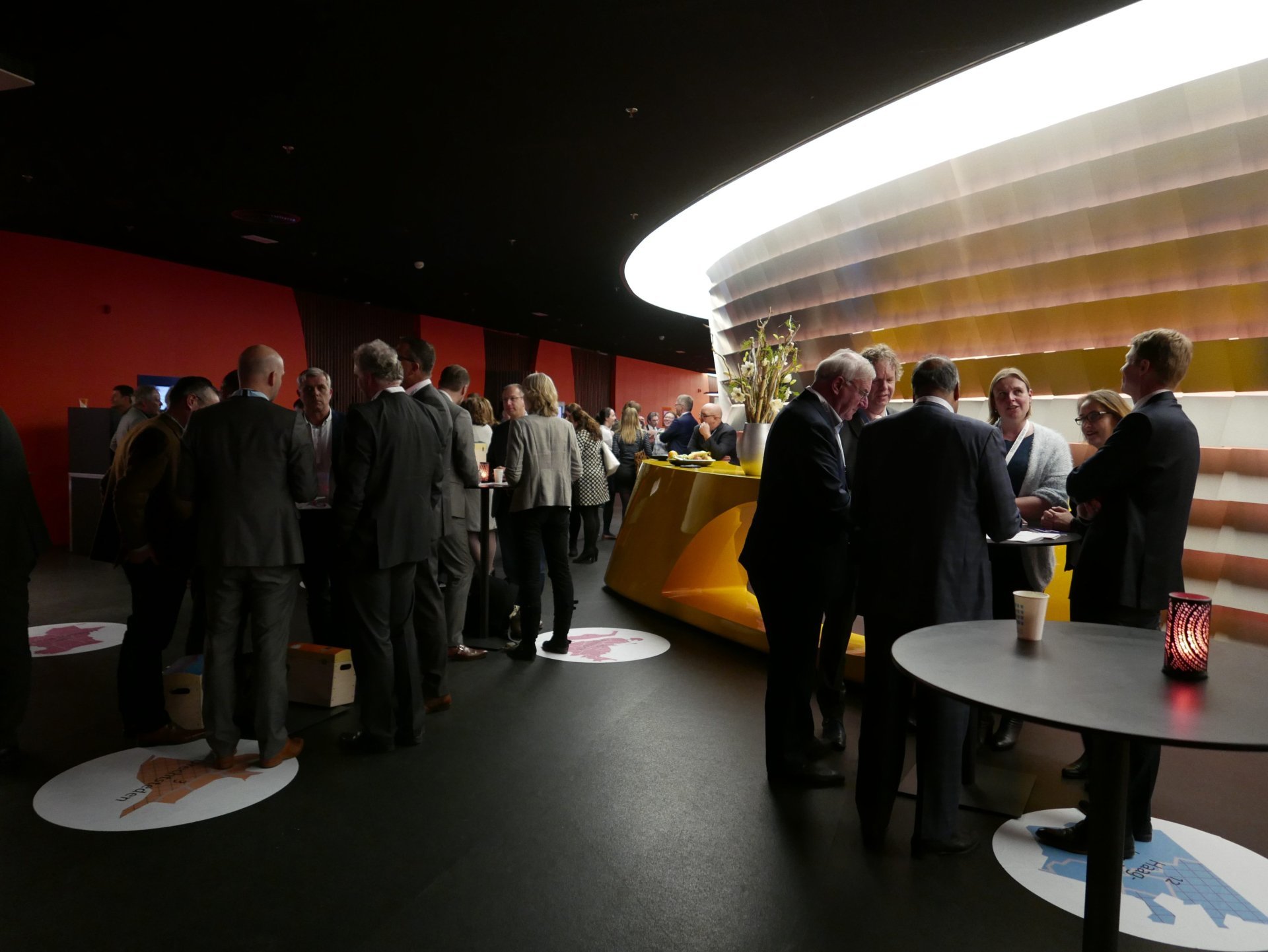 een groep mensen die in een kamer staan met een tafel en eten