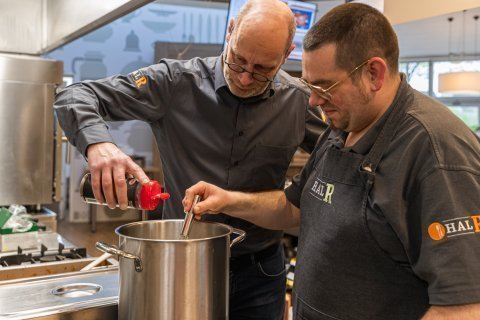 2 mensen zijn aan het koken op de open dag van MTB.