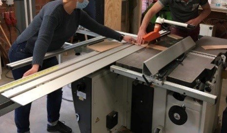 Medewerker aan de slag met de zaagtafel