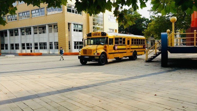 Bus2Talent, een Amerikaanse schoolbus staat bij een school om studenten te informeren over het werken en stagelopen aan de andere kant van de Nederlands-Duitse grens.