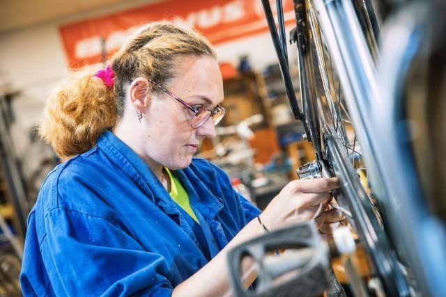 Medewerker sleutelt aan een fiets