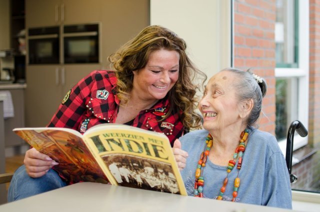 Roseanne Barr et al. zittend aan een tafel een boek te lezen